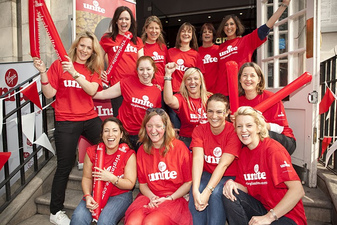 a group of women on steps wear red shirts from virgin moblie